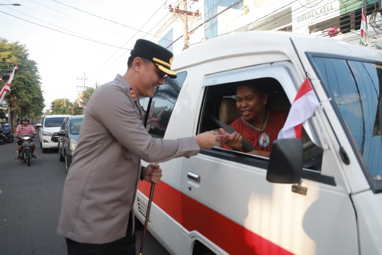 Tebar Semangat Merah Putih Kapolres Jember Turun Jalan Berbagi Bendera dan Cokelat 